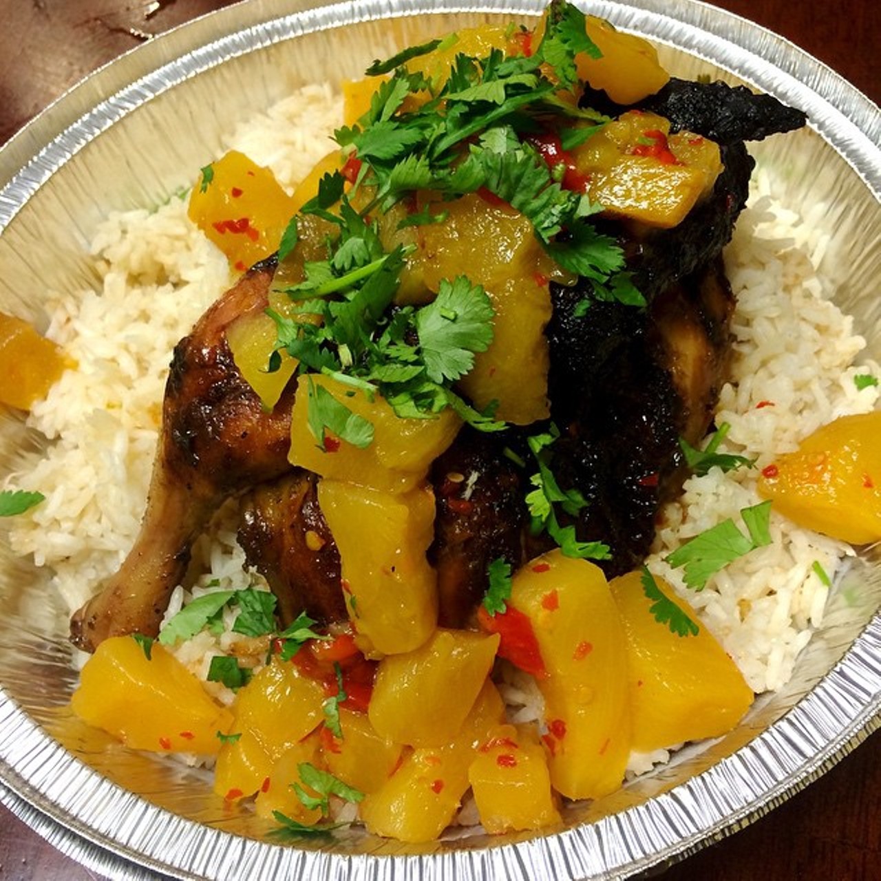 Coco tropical split rotisserie chicken served over coconut rice and a spicy pineapple and mango chutney from the Campus Grille.