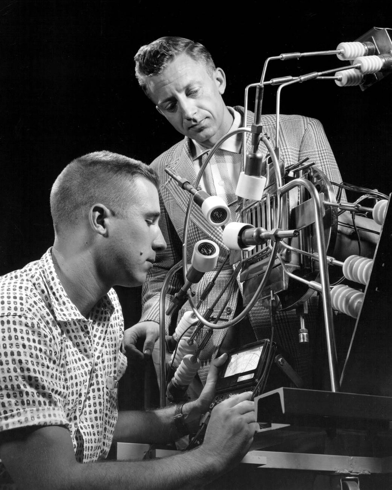 An engineer and a technician check out an ion engine in the Electronic Propulsion Research Building at the Lewis Research Center (now NASA's Glenn Research Center) in 1961.