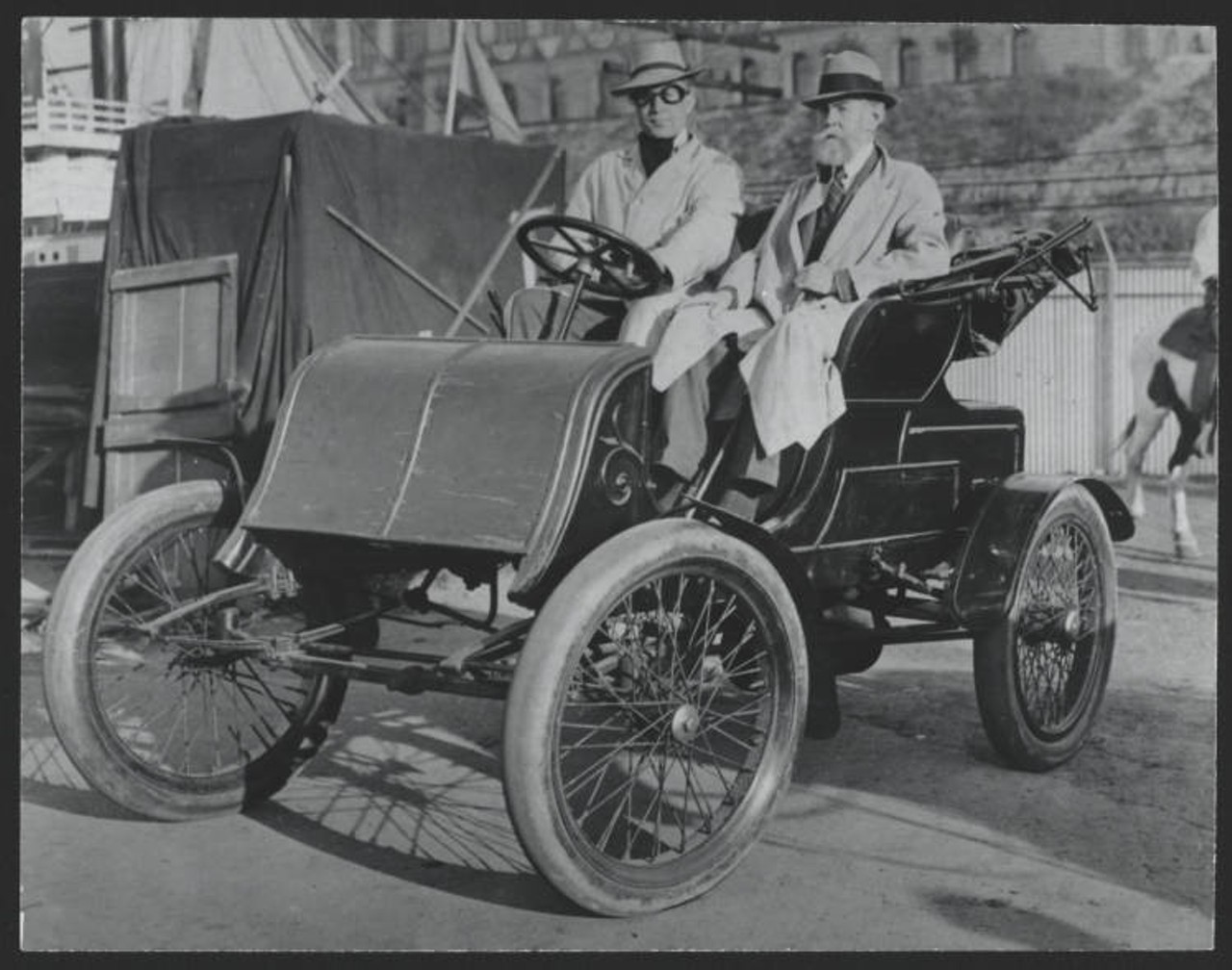 During the Great Lakes Exposition this early Winton car was used in the Parade of the Years. Mr. Charles A. Post, seated at the right, had ridden in this car when it was new. One day during the Exposition he was asked to ride in the parade for the sake of old times. The man at the left represented Alexander Winton. ca 1936-1937