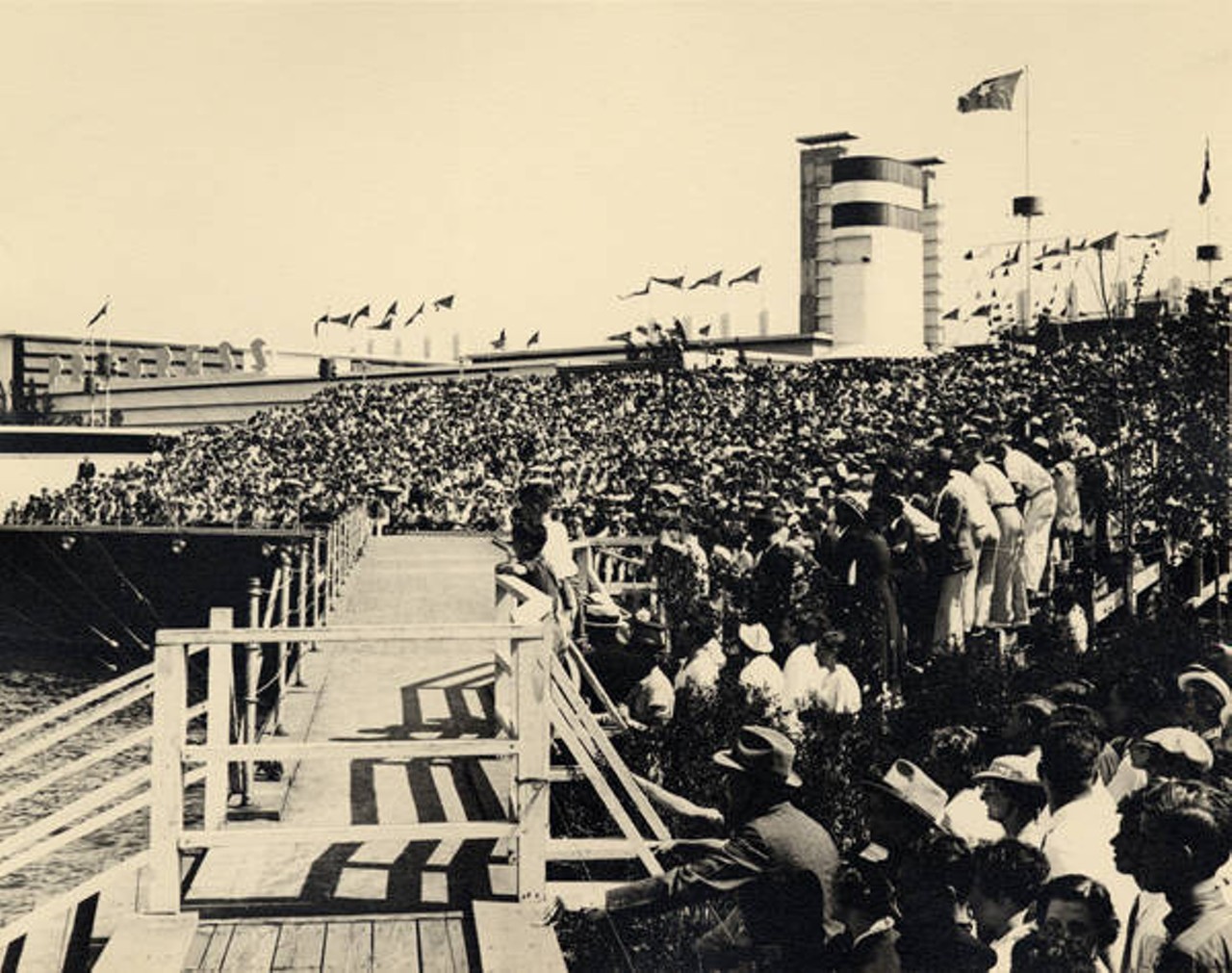 Audience in the stands during a performance at the Marine Theater; Hall of Progress in the background