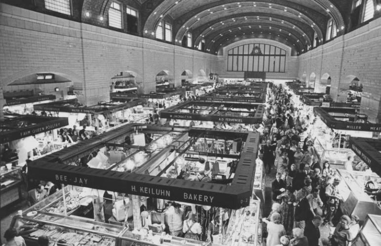 Interior view looking down from balcony. Signs are visible for market vendors Bee Jay, H. Keiluhn Bakery, W.J. Kovalcsik, A. D. Fernengel, Ken Loucka, Louis E. Weber, Farm Queen poultry, Walter f. Ehrnfelt, Kaufmann poultry, and Miller meats. c. 1971