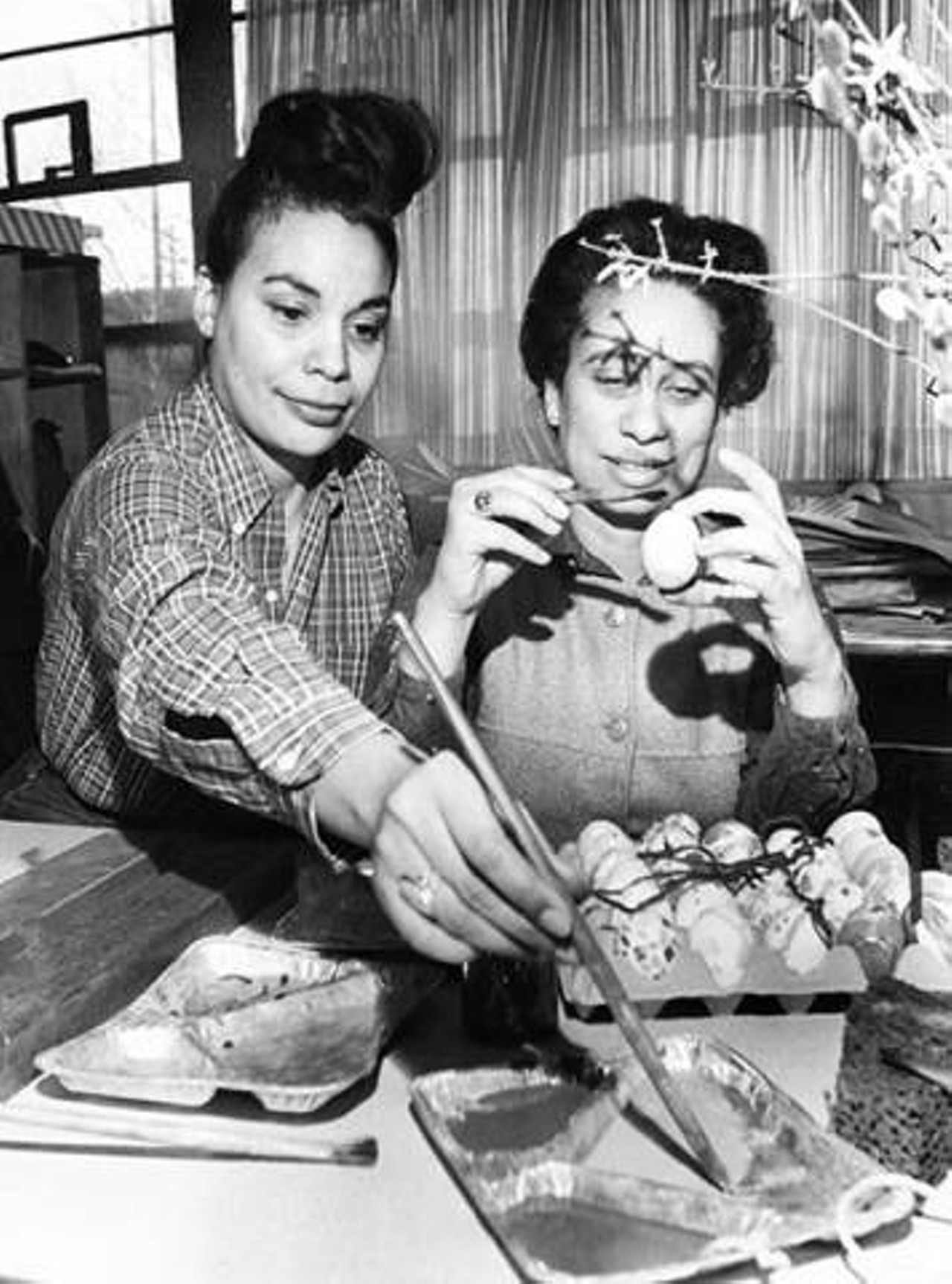 Cecil Rutledge and Mrs. Jane Dawson decorating Easter eggs at Karamu House Nursery School. 1965
