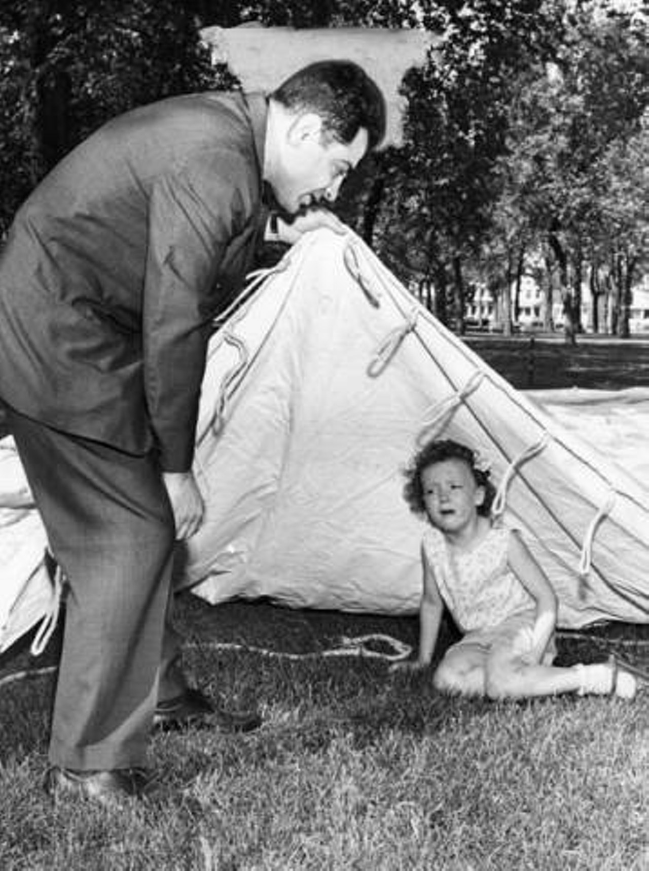 "Hiding under tent at Lincoln Park is Debra Brown, 6, of 2307 W. 5th St - found by David Antebi, director of W. Side Opportunity Fair ... Early visit to the Near West Side- Tremont Opportunity Fair was made today by Debra Brown, 6, of 2307 W. 5th St. shown being rescued from under the big tent at Lincoln Park by Fair Director David Antebi. The big tent will house many exhibits during the five-day celebration which begins tomorrow" -- photo verso.