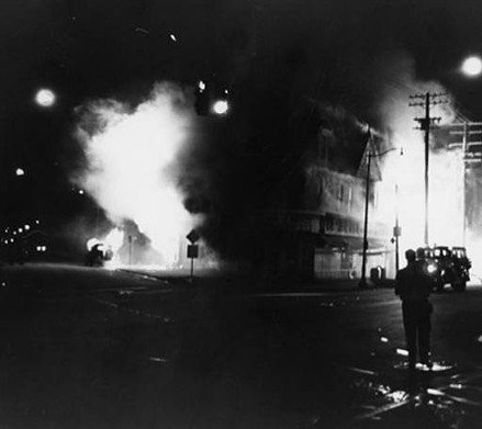 The All-Brite pharmacy and the Sav-Mor market burn in fires set by rioters.