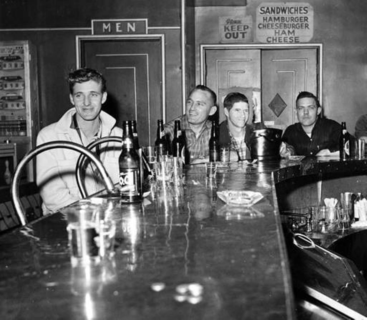 Imbibers seated around a bar, 1958.