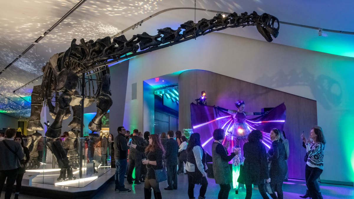 Party-goers dance under a dino at EPOCH 2024