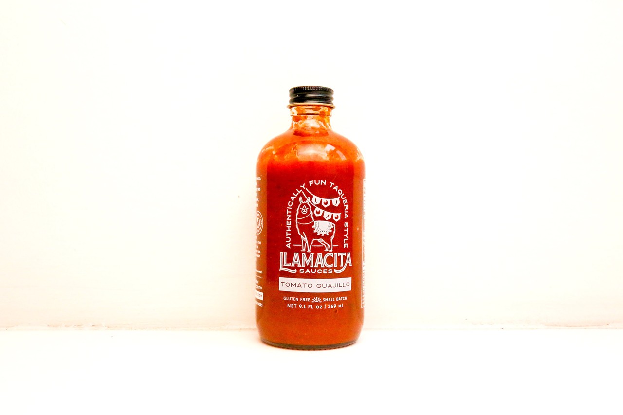 Llamacita
Look: It’s easy to see the vibrant red color of this Tomato Guajillo sauce through the 8-ounce glass bottle. The brand and product name are screen printed directly onto the glass, doing away with the need for a label. Naturally, there’s a cartoon llama on the front. 
Background: Bianca Beach grew up in the Pacific Northwest, lived in Southern California, and winded up in sunny Cleveland Heights, where she never stopped dreaming of those sauce-drenched SoCal tacos. In late 2023, she debuted her line of taqueria-style sauces under the Llamacita brand. 
“They are inspired by some of my favorite sauces at the taquerias I grew up going to and throughout my life,” she explains. 
Beach prefers the label “taco sauces” over hot sauces because they aren’t all hot. More importantly, they have a silky-smooth texture, like the sauces that flow effortlessly through the tops of squeeze bottles at the local taqueria. After releasing a green sauce, orange sauce and yellow sauce, Beach unveiled her magnum opus.
“Red was the last to be born,” she says. “It took some time, I don’t want to say to perfect it, but it took many iterations.”
Tasting notes: This sauce may be smooth and pourable, but it isn’t thin, one-dimensional or bland. It smells like a warm bowl of Texas chili and overflows with earthy, smoky spice from the guajillo chiles. There’s tomato in the sauce but this isn’t a tomatoey sauce by any stretch. Other than a slight tickle in the back of the throat, this sauce is largely heat-free. 
Uses: Micheladas, chili con carne, nachos, grilled steak, as a marinade for oven-roasted pork 
Heat index: 1/10
Find it at: Miles Market, Nature’s Oasis, Wine Spot, llamacitafoods.com