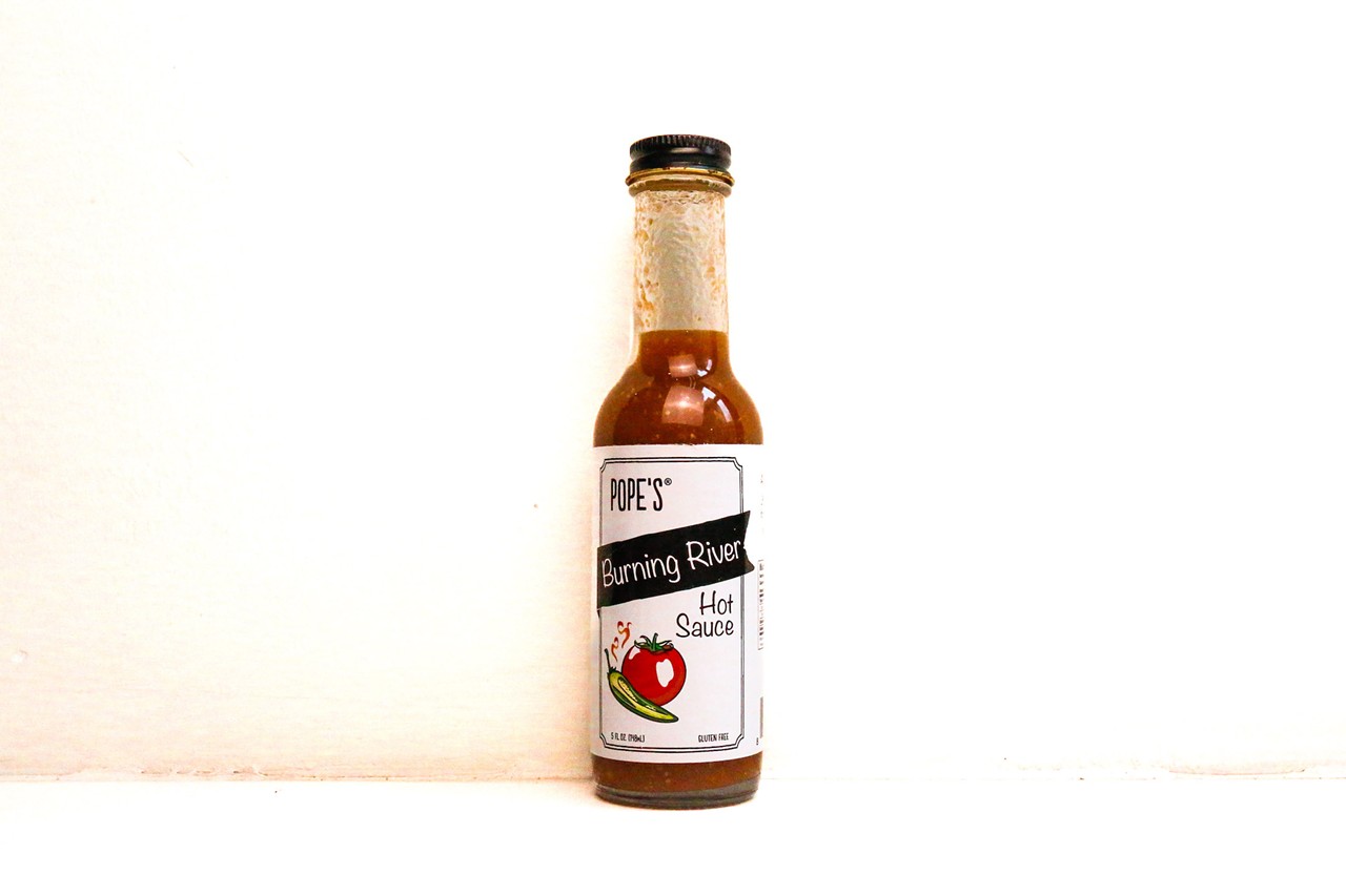 Pope’s
Look: A classic look for a classic sauce in the Burning River option. A mostly white label with a black “Burning River” banner and a two-color illustration of a tomato and chili pepper. 
Background: Clark Pope has been making commercial food products in Cleveland under the Pope’s brand for more than a decade. After the successful launch of his Bloody Mary sauce, he moved on to hot sauce, which was born out of a love for gardening, cooking and entertaining. 
“The beautiful thing about this hot sauce is that it’s just as simple as the day is long,” Pope explains.
Over the years, Pope has earned a level of trust and confidence among local food-product shoppers, who eagerly snatch up his latest creations. He also has become a respected mentor for other food-focused entrepreneurs looking to follow in his footsteps.  
Tasting notes: This is the type of hot sauce you would make in your kitchen at home if you had a little know-how, a lot of confidence and a bumper crop of tomatoes and hot peppers. The ingredients list might as well be the recipe: peppers, tomatoes, onion, garlic and apple cider vinegar. It’s a delightfully fresh, vibrant but uncomplicated sauce that goes on anything and everything. 
Uses: Scrambled eggs, pizza, quesadillas, mac and cheese, meatloaf
Heat index:3/10
Find it at: The Wine Spot, Heinen’s, Market District, popeskitchen.com