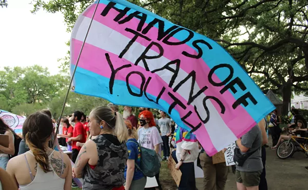 A transgender Pride flag is covered with the words &ldquo;Hands Off Trans Youth.&rdquo;