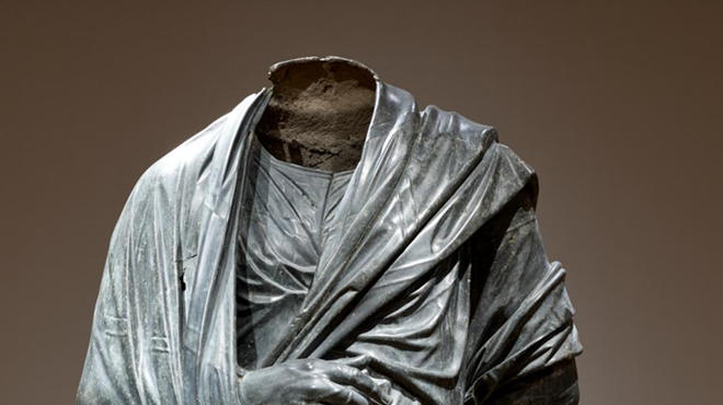 The museum’s current listing for the statue is titled “Draped Male Figure, c. 150 BCE–200 CE, Roman or possibly Greek Hellenistic”.