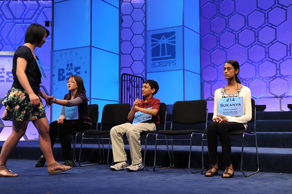 Two 2011 Scripps National Spelling Bee contestants high five while another claps. - PHOTO VIA FLICKR USER SCRIPPS NATIONAL SPELLING BEE