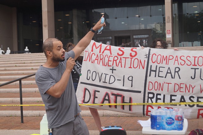 Speaker Dave Okpara gestures to the incarcerated in the county jail; Rally for Justice for Incarcerated Individuals, Cuyahoga County Justice Center, (5/29/20). - Sam Allard / Scene