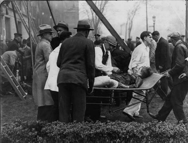 Officials assist a victim of the 1929 fire - Cleveland Memory Project