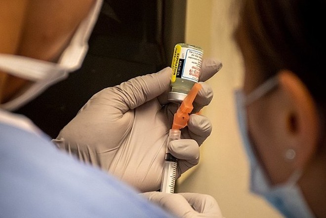Hospital personnel prepare to administer a dose of Moderna's COVID-19 vaccine. - NAVY MEDICINE