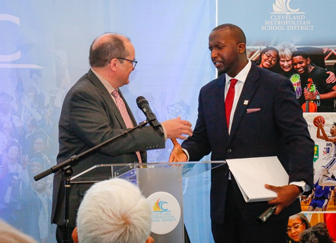 Eric Gordon, the soon-to-be former CEO of the Cleveland Metropolitan School District, hands off the baton to his replacement, Warren Morgan, on Tuesday. - Mark Oprea