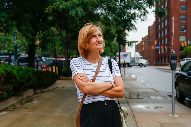 Angie Schmitt, a transportation activist, stands outside of the parking lot off West 9th St. and St. Clair Ave. where she filmed her documentary on “parking craters” 11 years ago. - Photo by Mark Oprea