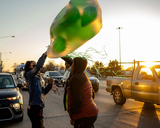 Diamond holds onto a bag of green balloons, Vincent’s favorite color, as she sets up to protest Vincent’s killing outside East Cleveland City Hall on March 5, 2021. After Vincent’s death, Diamond poured her time and money into organizing protests and asking for help from local activists, while she slept on couches and floors at friends’ houses. - Michael Indriolo for The Marshall Project
