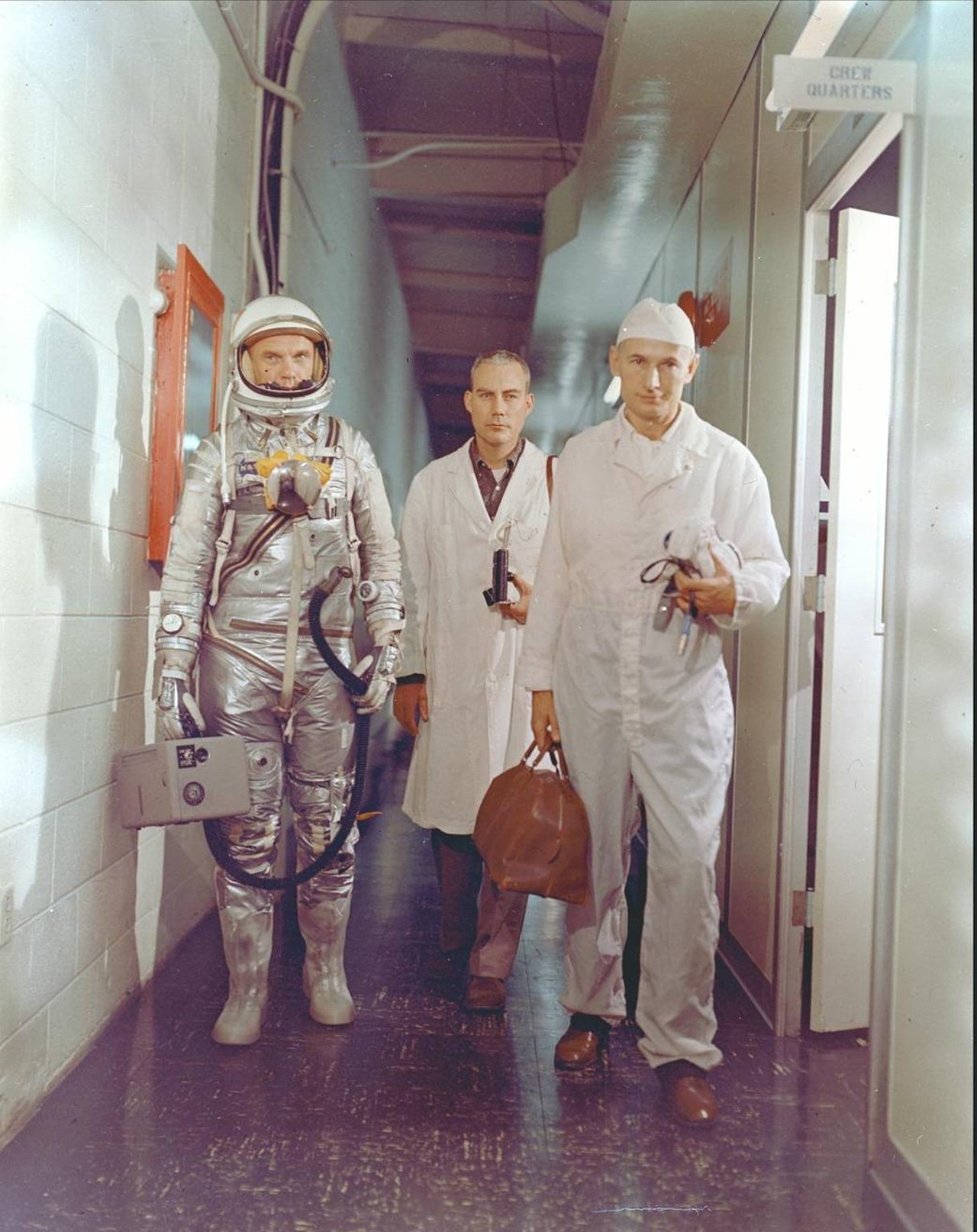 Astronaut John H. Glenn Jr., NASA flight surgeon William Douglas and equipment specialist Joseph W. Schmidt leave crew quarters prior to the Mercury-Atlas 6 mission.
