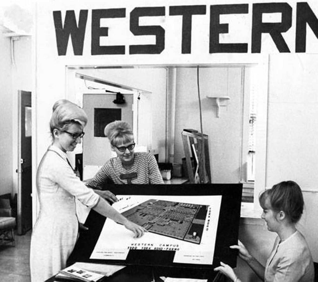 Female students looking at map and layout of Cuyahoga Community College West, 1966.