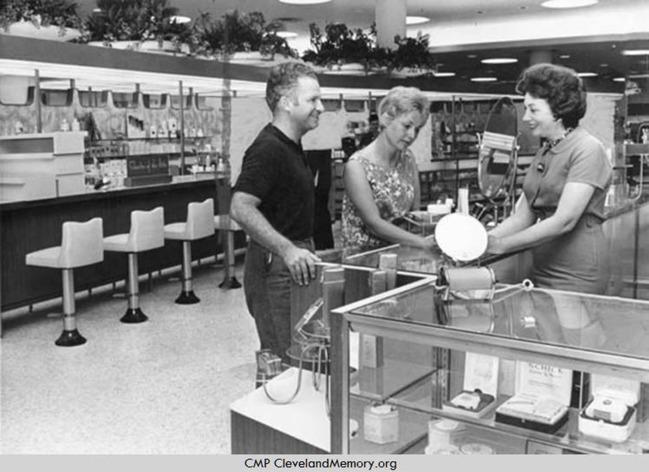 ''First customers at Higbee's new Severance Center store were Mr. and Mrs. Michael Kane, of 2245 Harcourt Dr., Cleveland Heights. They were served by saleswoman Mrs. Esther Harris, of 2440 Channing Rd., University Heights, shortly after the store opened at 10 this morning for a dry run preparatory to next Monday's formal opening.'' — photo verso, 1963